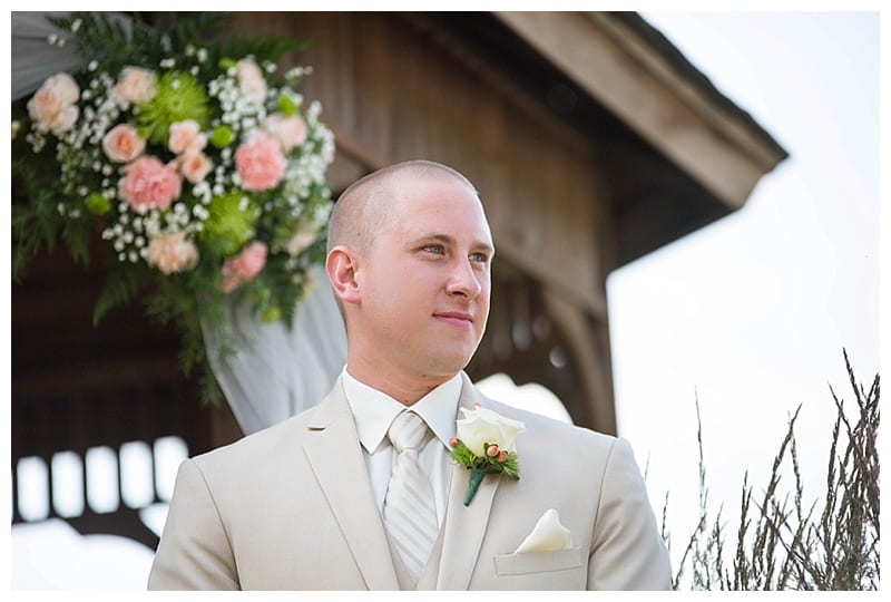Groom watching bride walk down aisle