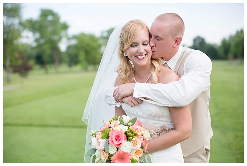 Groom kisses bride on cheek photos
