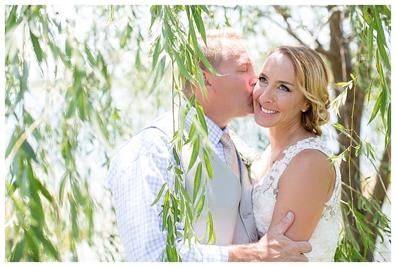 Groom kissing bride on cheek