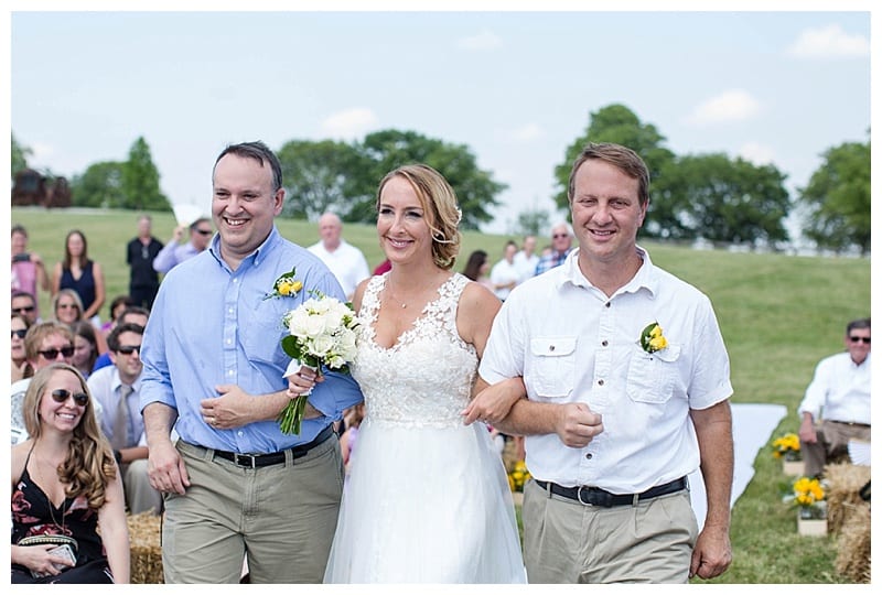 bride walking dow aisle with brothers